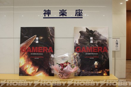 ▲新作『ＧＡＭＥＲＡ』の２種類のポスター前に、50周年記念の花が飾られた。